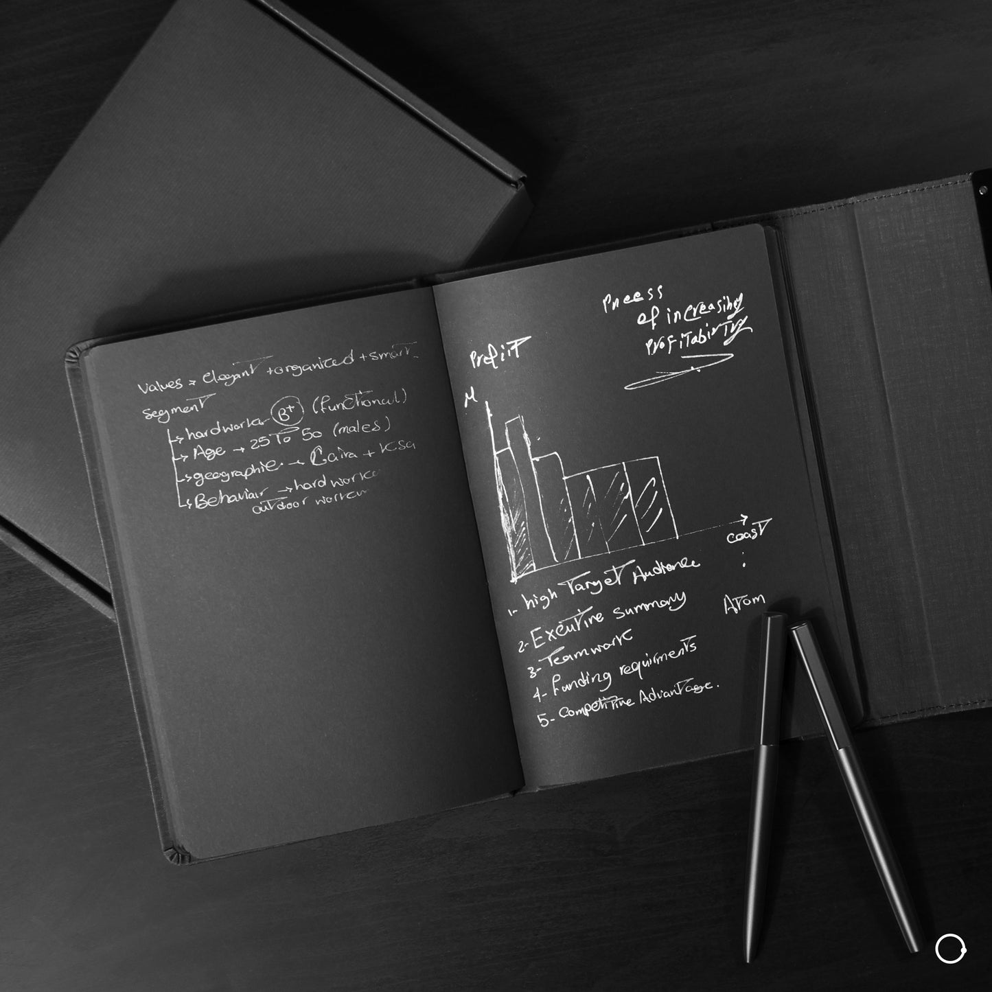 Black notebook and silver pen